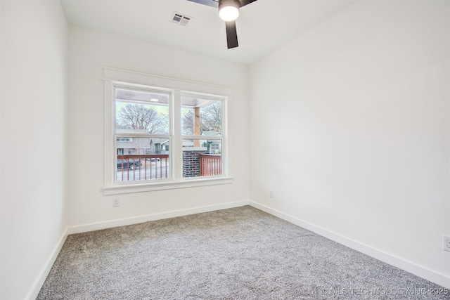 carpeted empty room with a ceiling fan, visible vents, and baseboards