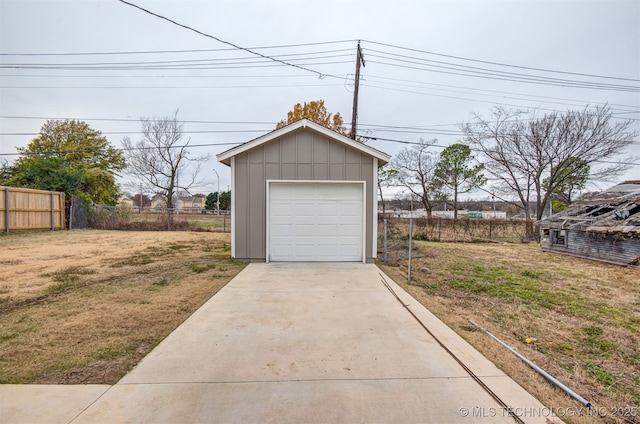 detached garage with fence and driveway