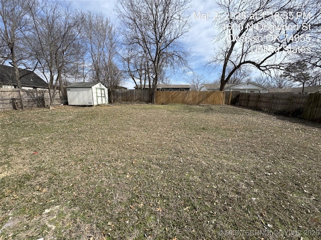 view of yard with a fenced backyard, an outdoor structure, and a shed