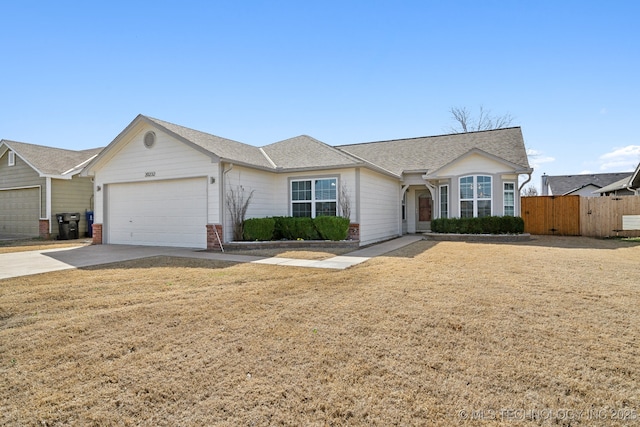 ranch-style home with fence, roof with shingles, an attached garage, concrete driveway, and brick siding