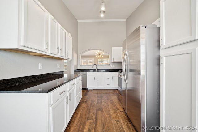 kitchen featuring a chandelier, appliances with stainless steel finishes, dark wood-style floors, white cabinetry, and a sink