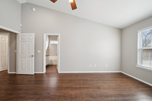 unfurnished bedroom featuring ceiling fan, baseboards, ensuite bathroom, dark wood-style floors, and high vaulted ceiling