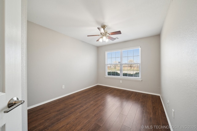 unfurnished room featuring a ceiling fan, dark wood-style floors, and baseboards