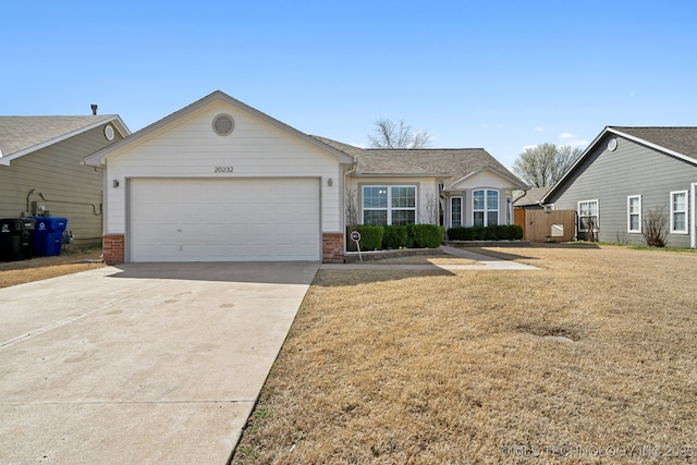 single story home featuring brick siding, a shingled roof, concrete driveway, a front yard, and an attached garage