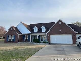 view of front facade with driveway, a front yard, and a garage