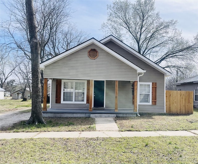 bungalow-style home with covered porch and fence