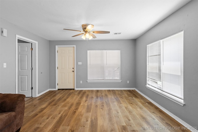 311 W 6th, Ada, OK 74820 - unfurnished living room with a ceiling fan and light wood-style floors