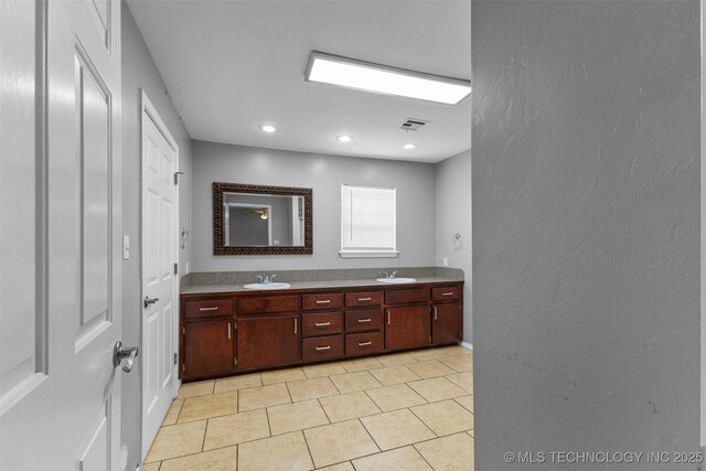 311 W 6th, Ada, OK 74820 - bathroom featuring double vanity, tile patterned flooring, a textured wall, and recessed lighting