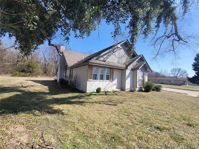 view of home's exterior featuring a yard and brick siding