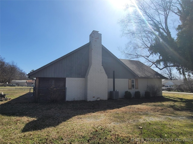 view of property exterior with brick siding, central AC unit, a lawn, and fence