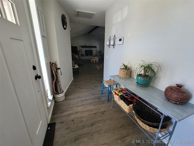 hall with visible vents, lofted ceiling, and wood finished floors