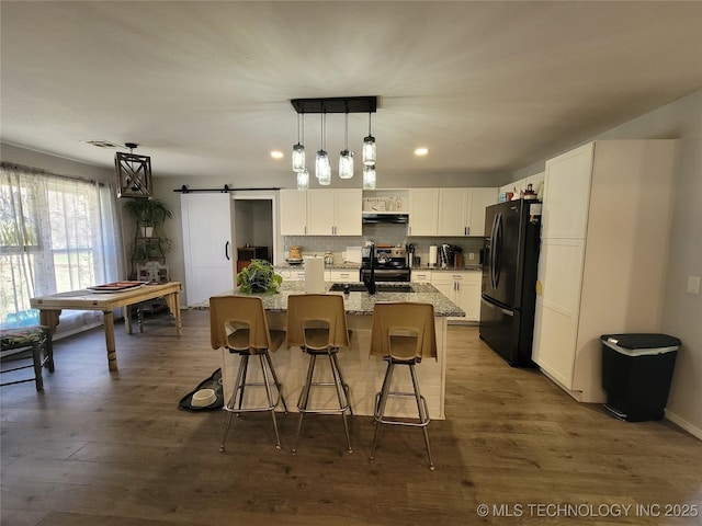 kitchen with white cabinets, electric stove, under cabinet range hood, tasteful backsplash, and black fridge