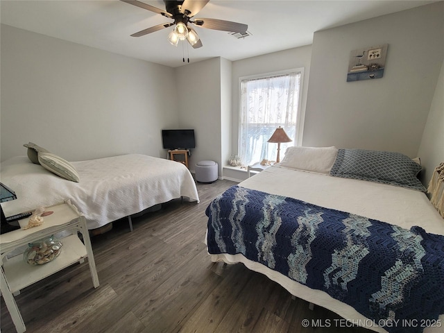 bedroom with visible vents, dark wood-type flooring, and a ceiling fan