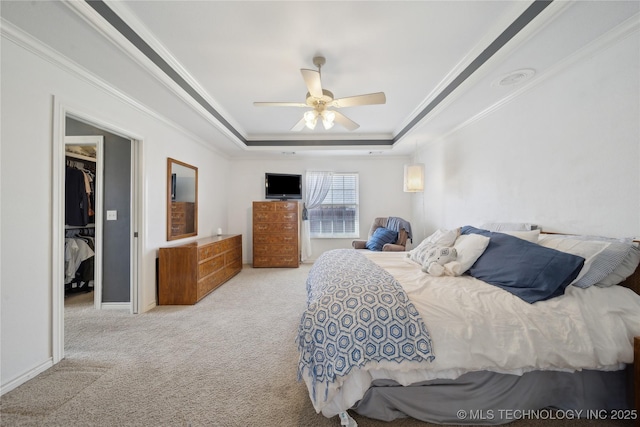 bedroom with a ceiling fan, carpet, baseboards, a tray ceiling, and ornamental molding