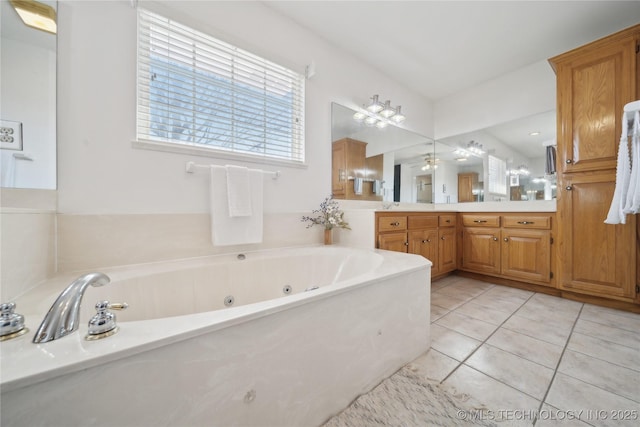 bathroom with a jetted tub, vanity, and tile patterned flooring