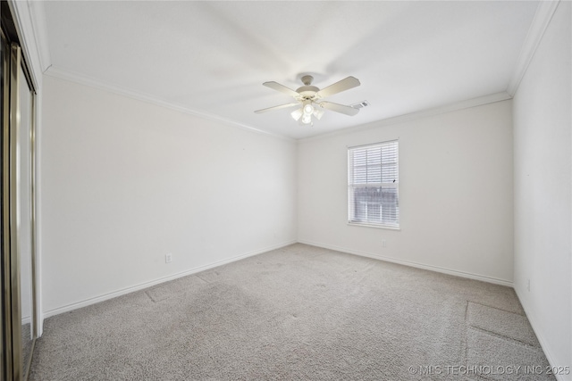 carpeted empty room with visible vents, baseboards, ceiling fan, and crown molding