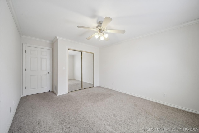 unfurnished bedroom featuring a closet, ornamental molding, a ceiling fan, and carpet floors