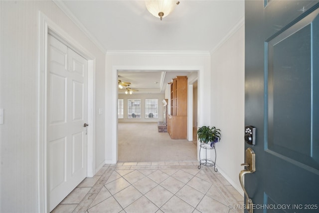 entrance foyer featuring ceiling fan, light carpet, ornamental molding, and light tile patterned flooring