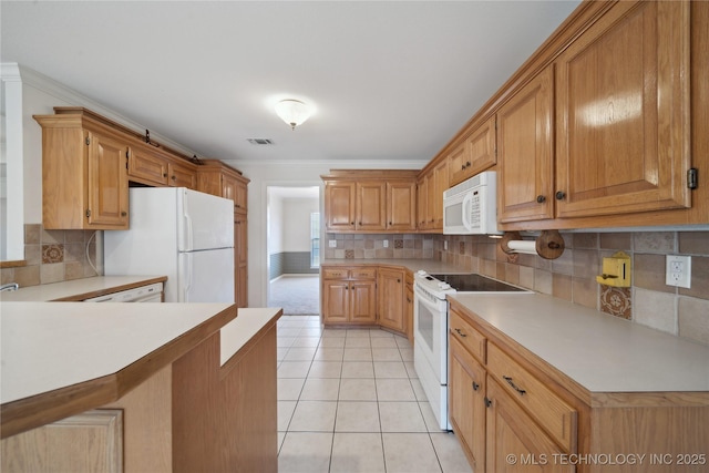 kitchen with white appliances, light tile patterned floors, visible vents, light countertops, and crown molding