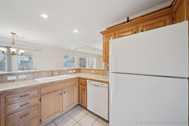 kitchen with a sink, white appliances, plenty of natural light, and light tile patterned flooring