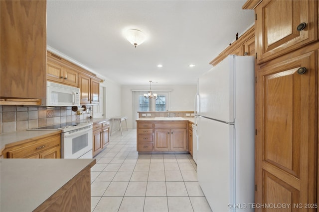 kitchen featuring a notable chandelier, a sink, white appliances, light countertops, and light tile patterned floors