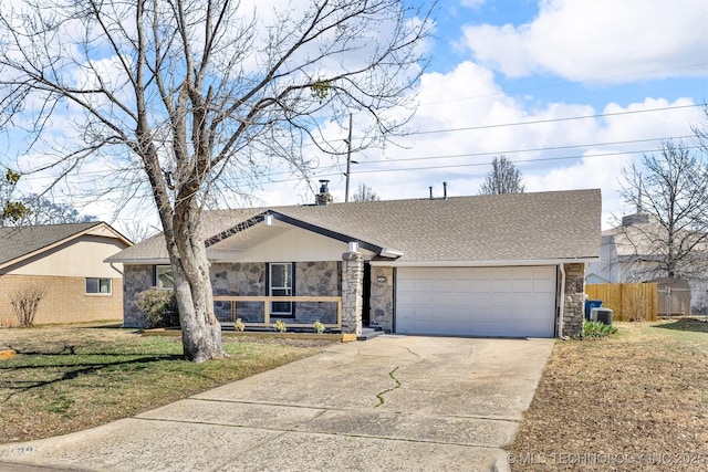 view of front of home with a front lawn, an attached garage, stone siding, and driveway