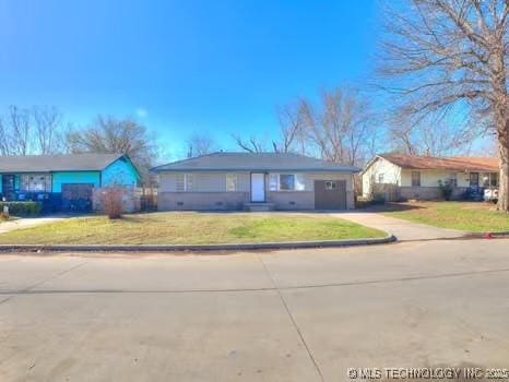 ranch-style home featuring a garage, concrete driveway, and a front yard