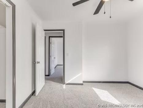 empty room featuring a ceiling fan and baseboards