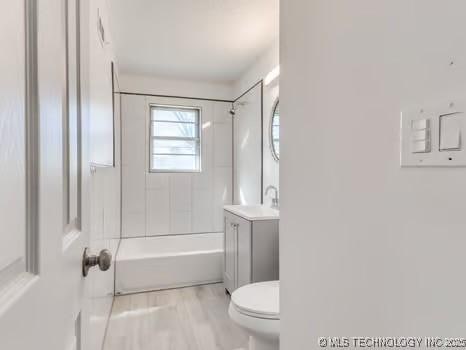 full bath with toilet, vanity, bathtub / shower combination, and wood finished floors