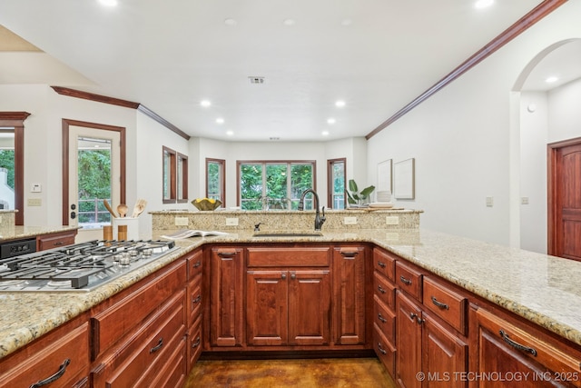 1721 E 136th Pl S, Bixby, OK 74008 - kitchen with stainless steel gas cooktop, arched walkways, light stone counters, recessed lighting, and ornamental molding