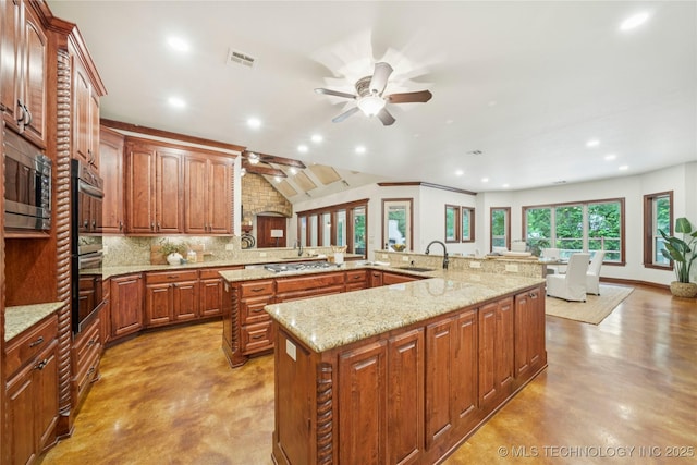 1721 E 136th Pl S, Bixby, OK 74008 - kitchen featuring ceiling fan, a large island, gas stovetop, tasteful backsplash, and concrete flooring