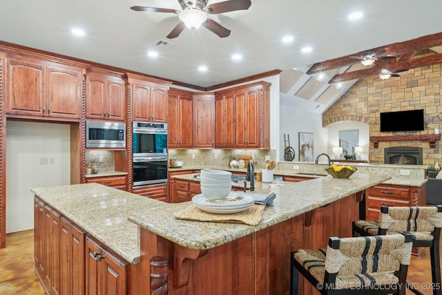 1721 E 136th Pl S, Bixby, OK 74008 - kitchen featuring a ceiling fan, appliances with stainless steel finishes, a kitchen breakfast bar, open floor plan, and recessed lighting