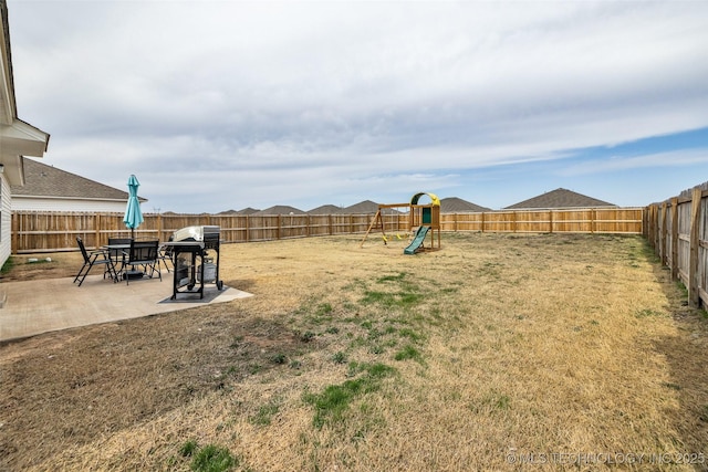 view of yard with a playground, a fenced backyard, and a patio area