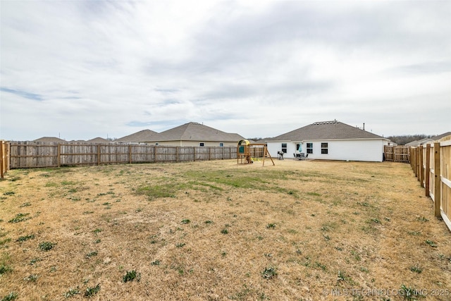 view of yard featuring a playground and a fenced backyard