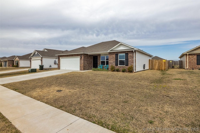 ranch-style home featuring brick siding, fence, a front yard, a garage, and driveway