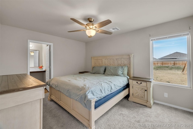 bedroom with visible vents, light colored carpet, baseboards, and ceiling fan