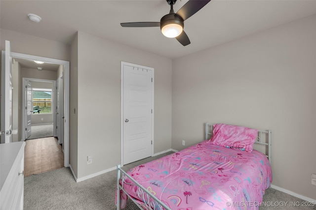 bedroom featuring light carpet, a ceiling fan, and baseboards