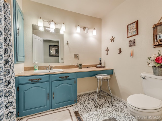 bathroom featuring tile patterned floors, baseboards, toilet, and vanity