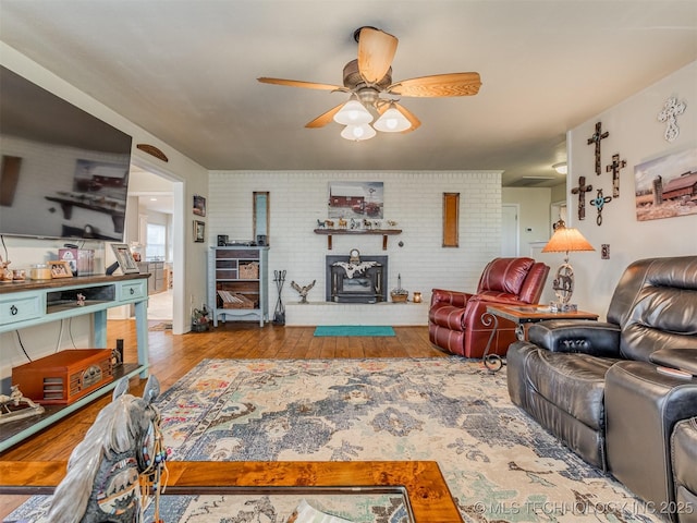 living area featuring brick wall, a ceiling fan, and hardwood / wood-style flooring