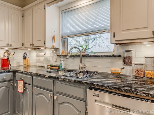 kitchen featuring backsplash, gray cabinetry, dishwasher, white cabinetry, and a sink