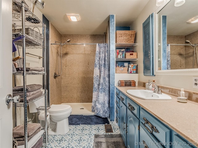 bathroom with tile patterned floors, toilet, a stall shower, and vanity