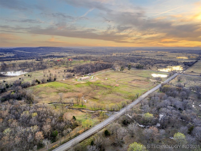 aerial view at dusk with a rural view and a water view