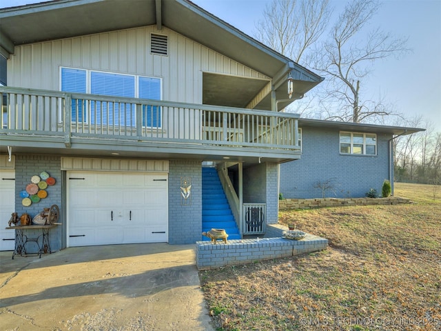 exterior space featuring board and batten siding, an attached garage, brick siding, and driveway