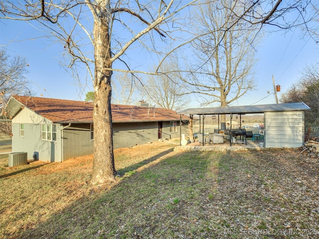 view of yard with central AC unit and an outdoor structure