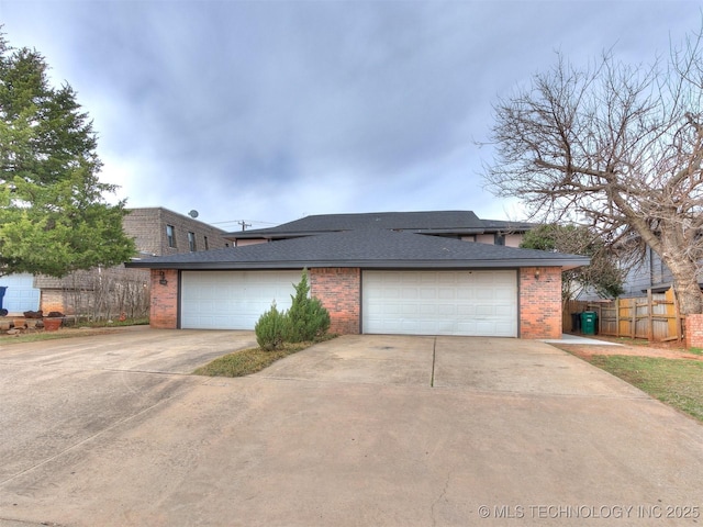 view of front of property with fence, a shingled roof, concrete driveway, a garage, and brick siding