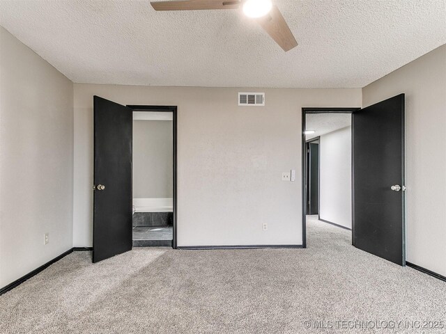 unfurnished bedroom with visible vents, a textured ceiling, baseboards, and carpet floors