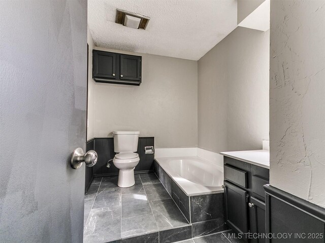 full bathroom with visible vents, toilet, a textured ceiling, a bath, and a textured wall