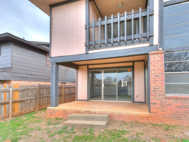 exterior space with a patio area, a balcony, and fence