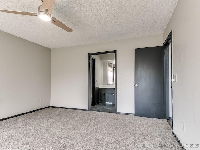 unfurnished bedroom with a ceiling fan, a textured ceiling, connected bathroom, carpet, and baseboards