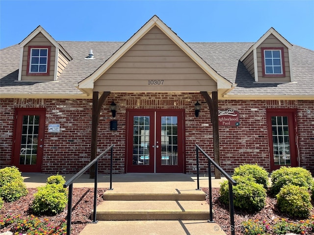 11906 E 99th St, Owasso, OK 74055 - property entrance with french doors, brick siding, and roof with shingles